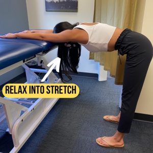 Girl performing a shoulder stretch using a tall table