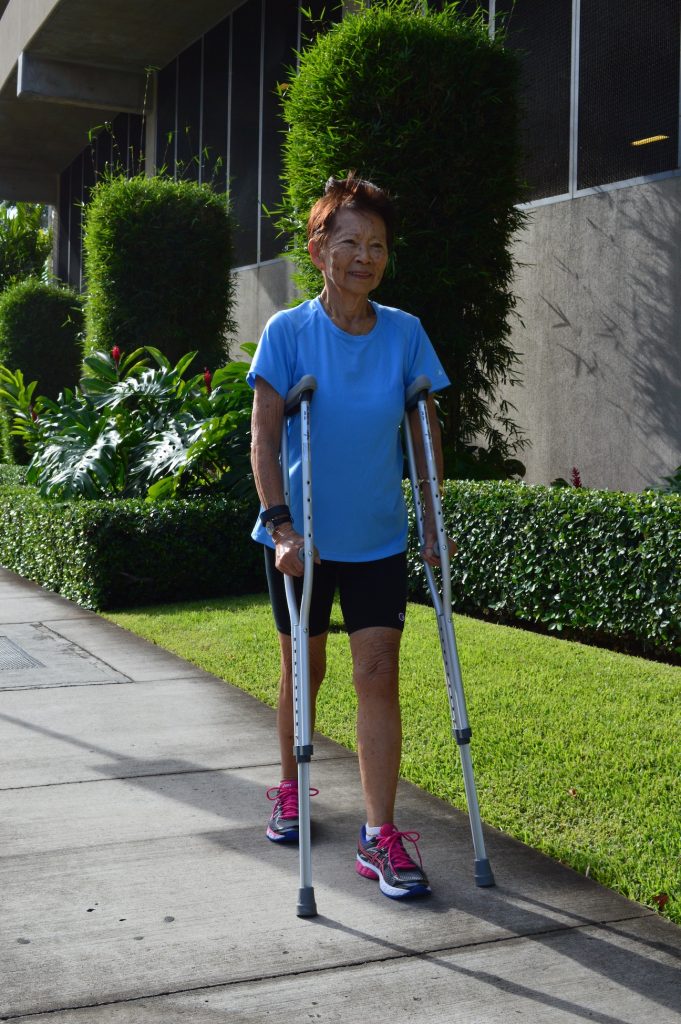 woman walking on crutches outside