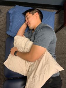Person sleeping on his side with a pillow