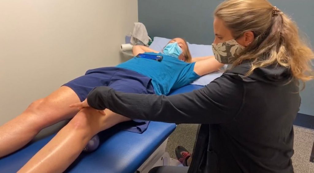 Physical therapist treating a woman's knee