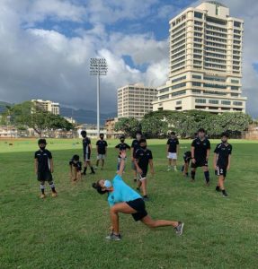 Physical therapist instructing injury prevention exercises to a team