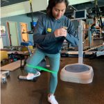 Physical therapist demonstrating the movement during a standing hydrant exercise