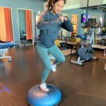 Woman hopping to the side onto half BOSU