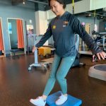 Woman demonstrating a single leg squat on uneven surface