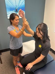 Person passively moving another person into shoulder flexion