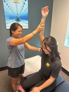 Person passively moving another person into shoulder flexion